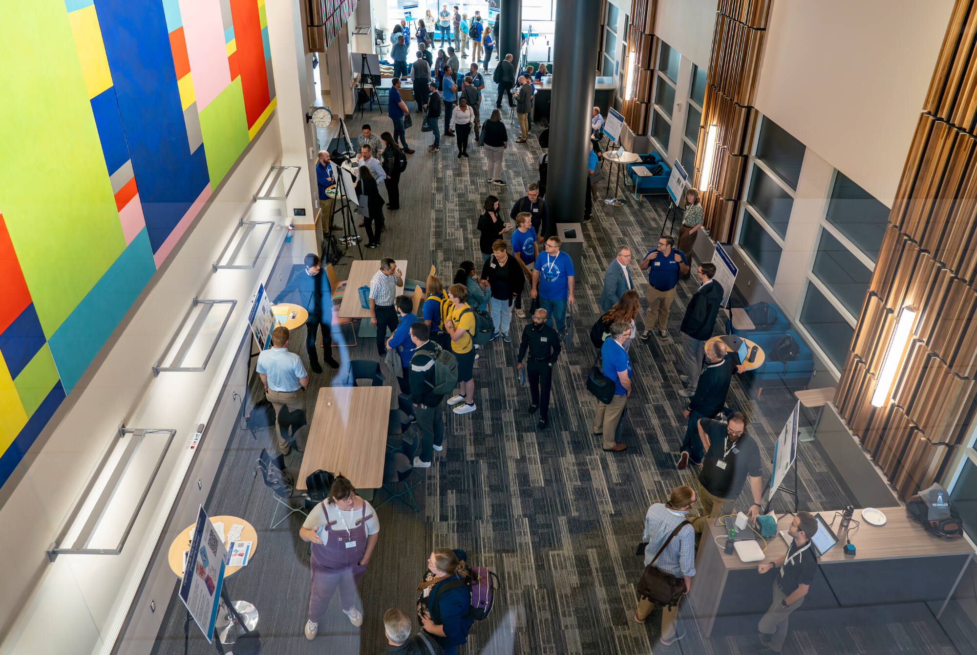 People talk and view posters at the 2025 GV Technology Summit
